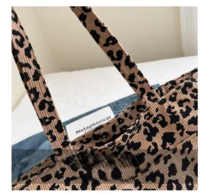 Gros plan sur la couture de la poignée du sac cabas en velours côtelé imprimé léopard