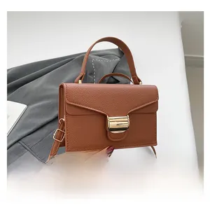 Détail du sac à main en cuir marron grainé avec boucle métallique dorée en forme de U