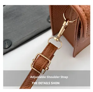 Détail de la bandoulière réglable en cuir grainé marron avec boucles en métal doré