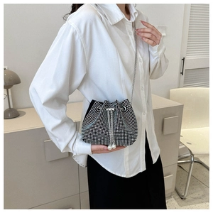 Detail of black drawstring bucket bag with silver rhinestones and pearl accents
