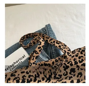 Gros plan sur la texture léopard du sac cabas et ses larges poignées en tissu velours