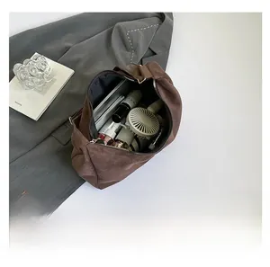 Interior view of large capacity dark brown suede tote bag showing tablet and daily items