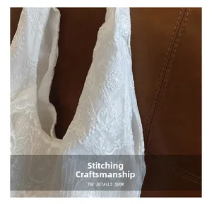 Detailed embroidery on white lace tote bag showcasing premium stitching and floral patterns