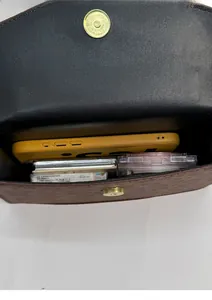 Internal view of the brown leather bag showing storage space for phone and makeup