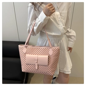 Detail of pink monogram tote bag featuring a front pocket and long leather straps