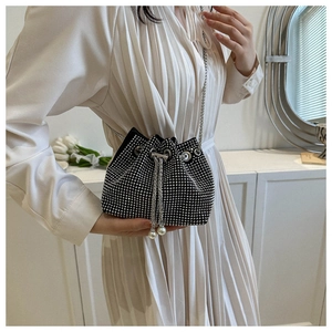 Detail of black rhinestone drawstring bucket bag with silver chain and pearl accents