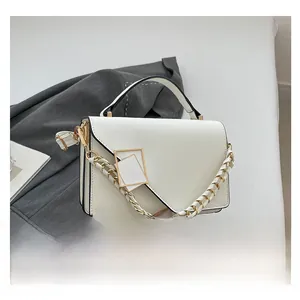 Close-up of a white leather crossbody bag featuring a golden geometric buckle and chain