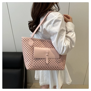 Pink tote bag with geometric print and front flap pocket shown on model's shoulder