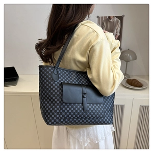 Detail of blue tote bag featuring light blue polka dot patterns and front black pocket