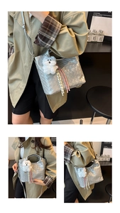 Detail of silver woven bucket bag with plush dog charm and tassels on shoulder strap