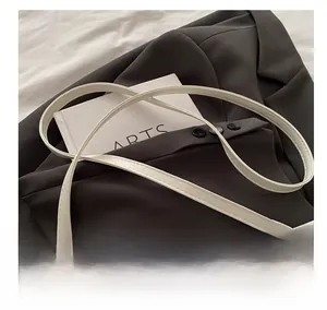 Detail der weißen gesteppten Ledertasche mit Nieten und verstellbarem Schultergurt