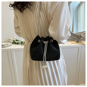 Close-up of black rhinestone drawstring bucket bag with silver chain and pearl details