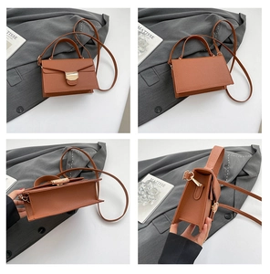 Vue détaillée du sac à main en cuir marron grainé avec fermoir doré et bandoulière amovible