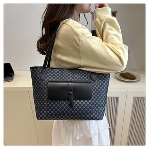 Detail of large tote bag with blue geometric pattern and black leather pocket flap