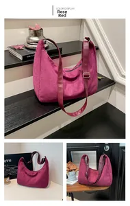 Primer plano del bolso hobo de ante rojo rosa mostrando textura suave y hebillas
