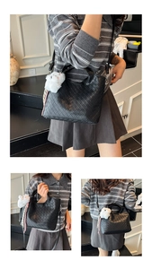 Close-up of black woven leather bucket bag featuring a cute plush cat charm and silk ribbon