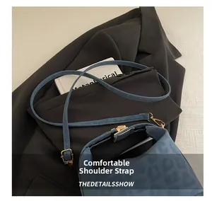Detail of light blue leopard-embossed leather bag with adjustable golden shoulder buckle