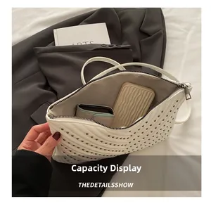 Detail der Innenkapazität und V-Steppung mit silbernen Nieten auf der Umschlagtasche