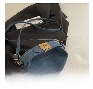 Detail of blue animal print crossbody bag showing the golden metal lock and zipper closure