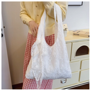 Detailed embroidery on white lace tote bag with a decorative floral ribbon bow