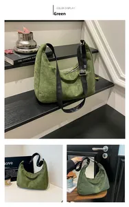 Detalle del bolso hobo de ante verde oliva con correa de cuero negro y hebillas