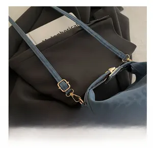 Detail of adjustable golden metal buckle on blue suede tote bag with matte texture finish
