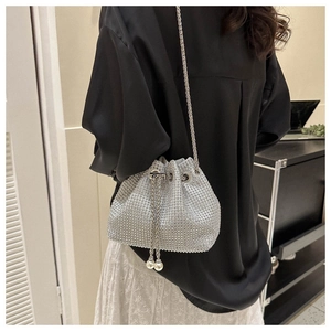 Detail of silver rhinestone bucket bag with chain strap and pearl drawstring accents