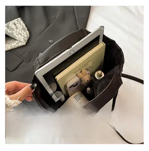 Interior view of large capacity dark brown woven tote bag holding tablet and notebook