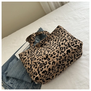 Détail de la texture en velours côtelé léopard et des anses robustes du grand sac cabas