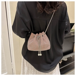 Pink rhinestone bucket bag with pearl drawstring and silver chain shown on a model