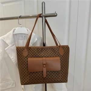 Vintage brown monogram tote bag with front pocket shown on a stylish hanger display