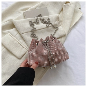 Detail of pink drawstring bucket bag with shiny rhinestones and elegant pearl accents