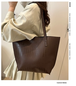 Detail of dark brown tote bag with crocodile pattern texture for commuting fashion