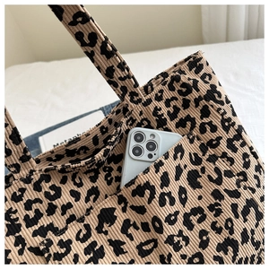 Détail du sac cabas en velours côtelé léopard avec poche avant et texture du tissu