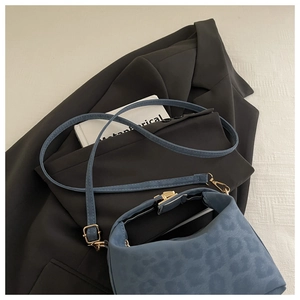 Détail du sac bandoulière bleu à motif léopard avec fermoir en métal doré brillant