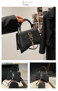 Detail of black sequined crossbody bag with gold S-shaped logo and elegant long fringe