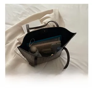 Spacious brown crocodile pattern tote bag interior showing capacity for tablets and daily items