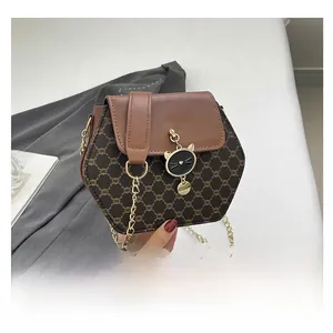 Détail du sac hexagonal à monogramme marron avec pendentif chat et chaîne dorée