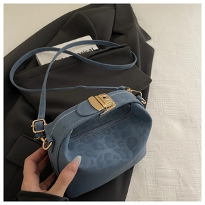 Gros plan du sac bandoulière léopard bleu avec fermoir doré et texture en daim doux
