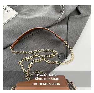Détail de la bandoulière confortable en cuir marron et chaîne dorée du sac à main