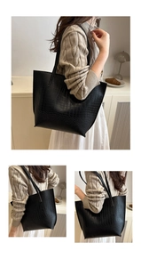 Detailed view of crocodile embossed texture on a black vintage tote bag with dual straps