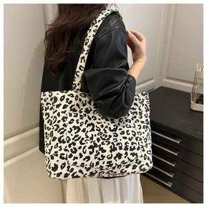 Vue détaillée du grand sac cabas en velours côtelé léopard porté sur une veste en cuir