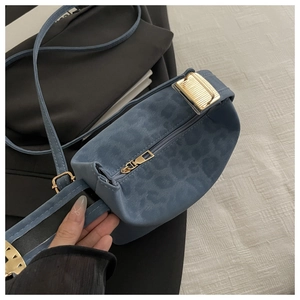 Gros plan sur un sac bandoulière léopard bleu avec zip doré et texture en daim doux