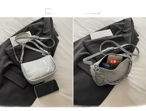 Sac bandoulière argenté effet marbré montrant l'intérieur spacieux et la poignée en chaîne