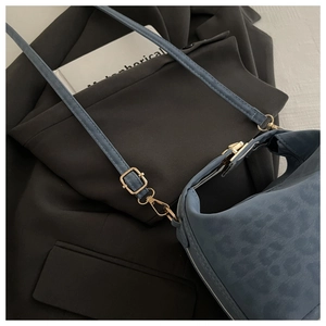 Détail du sac à bandoulière bleu motif léopard avec boucle en métal doré texturé
