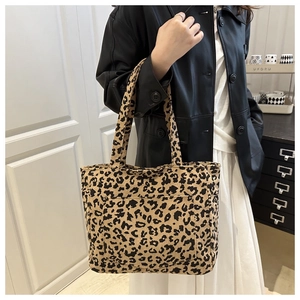 Sac cabas en velours côtelé léopard chic porté avec veste en cuir dans un décor intérieur