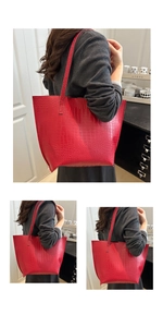 Macro view of red crocodile embossed tote bag texture with slim leather shoulder straps