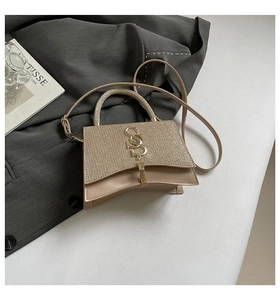 Detail of champagne gold crossbody bag with sequins and elegant metal tassel pendant