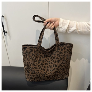 Gros plan sur la texture velours léopard d'un grand sac cabas tenu par une personne