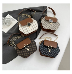 Détail de sacs hexagonaux avec fermoir en forme de chat et imprimé monogramme